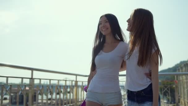 Chicas positivas caminando sobre fondo urbano — Vídeo de stock