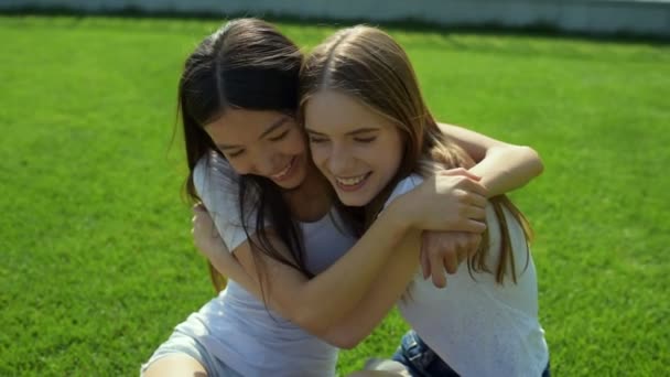 Relaxante positivo meninas abraçando na grama — Vídeo de Stock