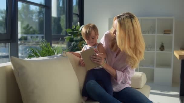 Belle mère assise sur le canapé avec l'enfant — Video