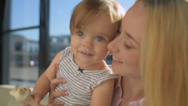 Улыбающаяся мать держит прекрасного ребенка — стоковое видео
