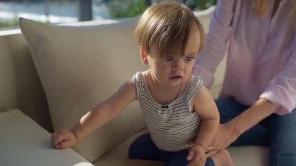Закройте ребенка, сидящего на диване — стоковое видео