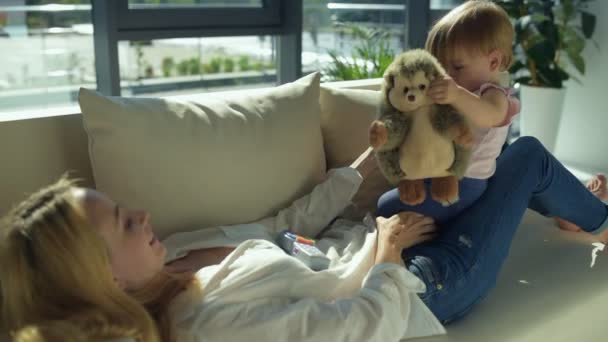 Härlig tjej med leksaker som sitter på soffan — Stockvideo