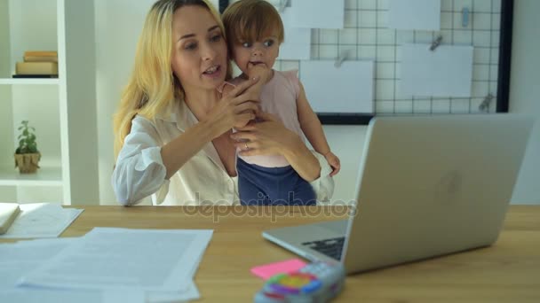 Schöne Mutter hält ein Baby und winkt mit der Hand — Stockvideo