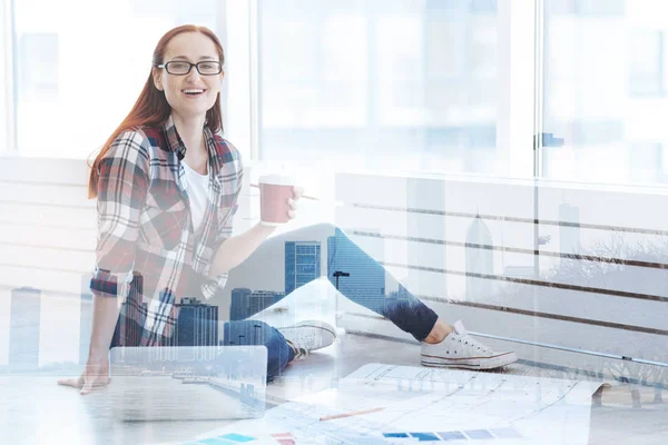 Sorridente donna che beve caffè nel suo ufficio — Foto Stock