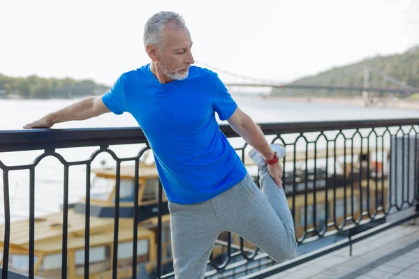 Senior man warming up before morning run — Stock Photo, Image