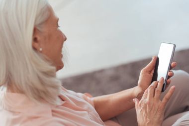 Neşeli kadın kıdemli akıllı telefonunu evde kullanma
