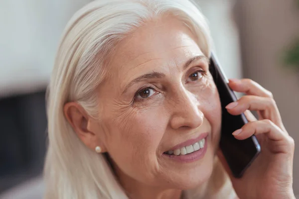 Портрет сеньора улыбающейся женщины, разговаривающей по телефону — стоковое фото