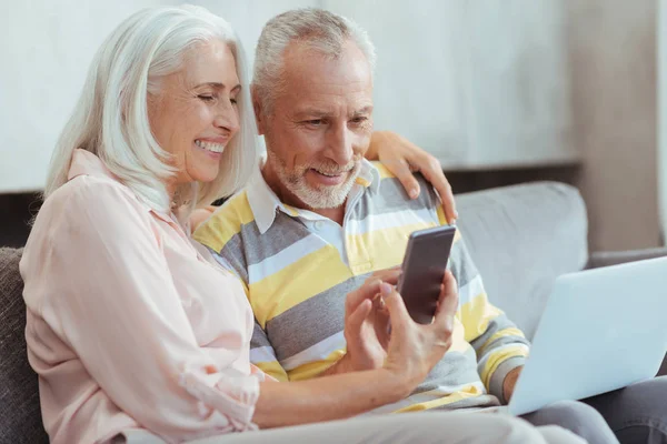 Pareja de edad muy alegre utilizando dispositivos modernos —  Fotos de Stock