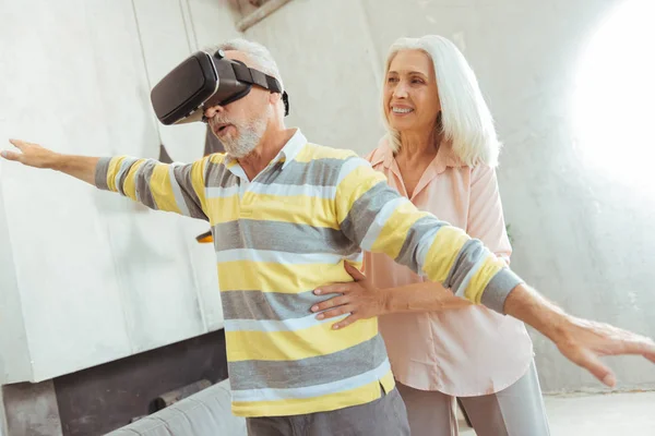 Agradable anciano hombre probando gafas VR con su amante esposa —  Fotos de Stock