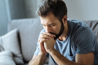 Mutsuz genç adam çenesini tutarak