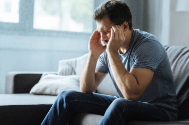 Bir baş ağrısı olan üzgün yakışıklı adam
