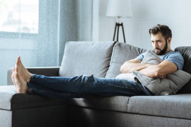 Bir yastık tutan mutsuz depresif adam