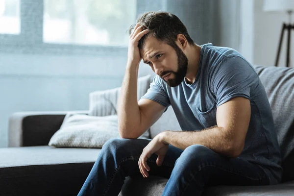 Triste homem sombrio segurando sua testa — Fotografia de Stock