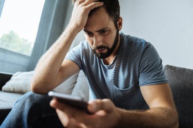 Onun smartphone tutan ponponsuz kasvetli adam