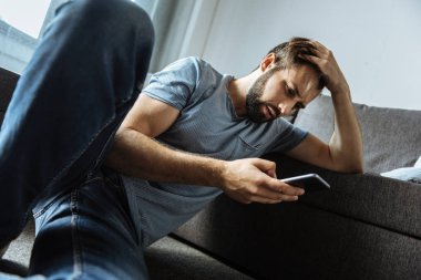 Onun smartphone kullanarak depresif yakışıklı adam