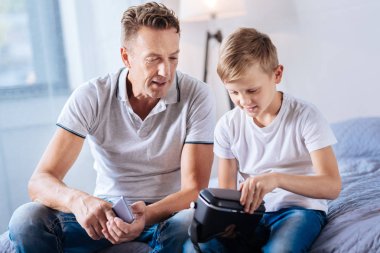 Baba oğlu VR kulaklık açmaya çalışırken izlemek