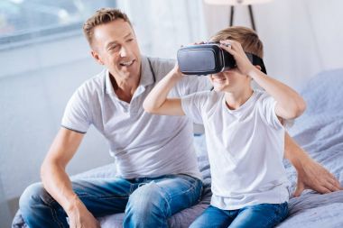 Mutlu baba oğlu VR kulaklık üzerinde çalışırken izlemek