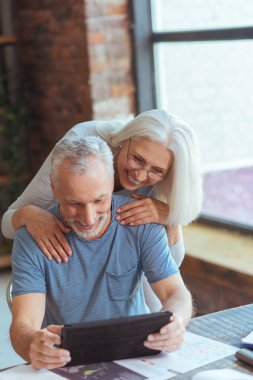 Neşeli yaşlı çift evde tablet kullanma