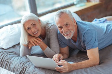 Dinlenme süre yatakta yatan gülümseyen yaşlı çift