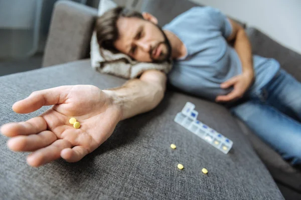 Foco seletivo de pílulas deitadas na palma da mão masculina — Fotografia de Stock