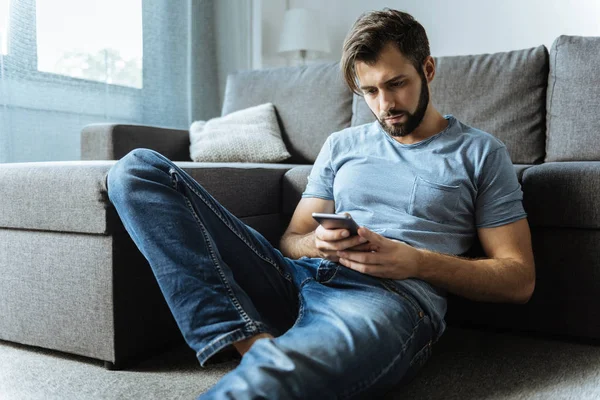 Triste homem bonito verificando suas mensagens — Fotografia de Stock