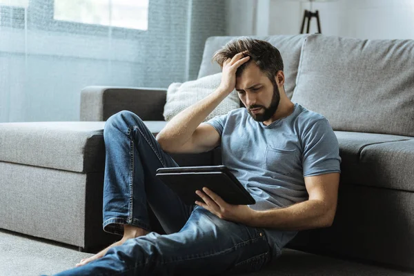 Trevlig olycklig man sitter på golvet — Stockfoto