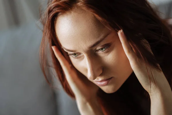 Fröhliche junge Frau hält ihre Schläfen — Stockfoto