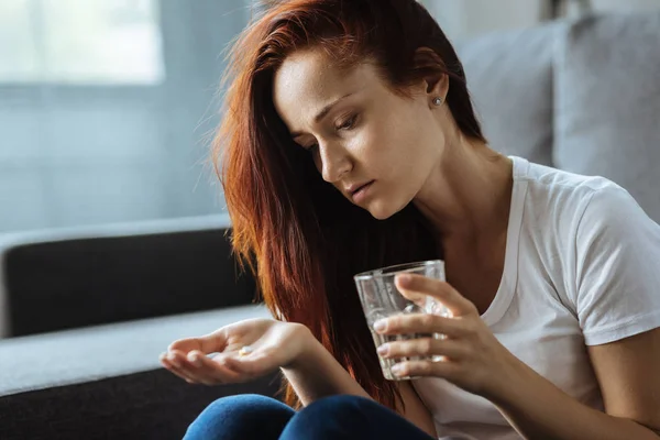 Mujer atractiva sin alegría sosteniendo un vaso de agua —  Fotos de Stock