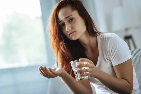 Traurige hübsche Frau nimmt Medikamente — Stockfoto