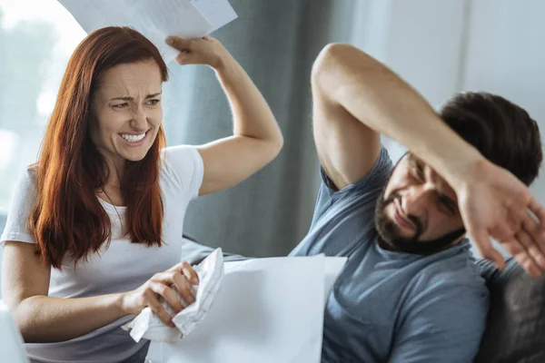 Irritada mulher emocional batendo seu namorado com papel — Fotografia de Stock