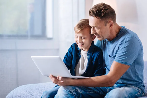 Zorgzame vader kijken cartoons met zijn zoon op laptop — Stockfoto