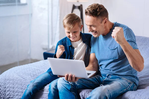 Веселые отец и сын смотрят футбол онлайн — стоковое фото