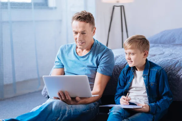 Padre e hijo viendo video educativo juntos — Foto de Stock