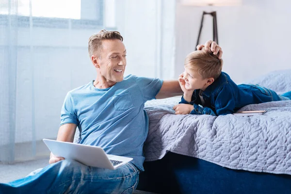 Feliz padre joven volteando el pelo de sus hijos — Foto de Stock