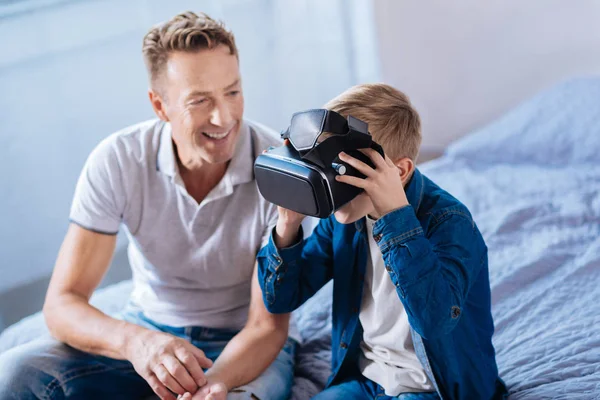 Onun oğlu test Vr kulaklık izlerken neşeli baba