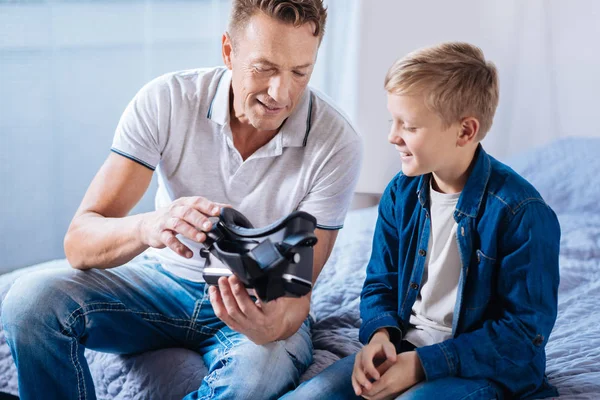 Agradable padre mostrando a su hijo nuevos auriculares VR — Foto de Stock