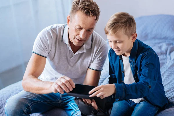 Pai e filho curiosos inspecionando novos fones de ouvido VR — Fotografia de Stock