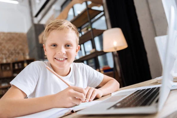 Radostný chlapec psaní si potřebné informace do poznámkového bloku — Stock fotografie