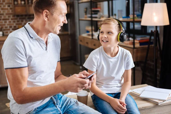 Pai feliz ligando música para seu filho em fones de ouvido — Fotografia de Stock