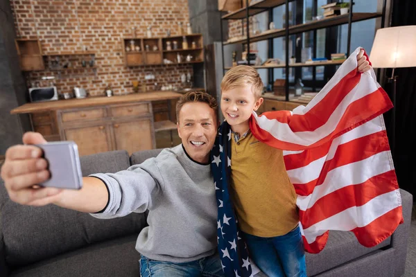 Pai feliz tirando selfies com filho na bandeira dos EUA — Fotografia de Stock