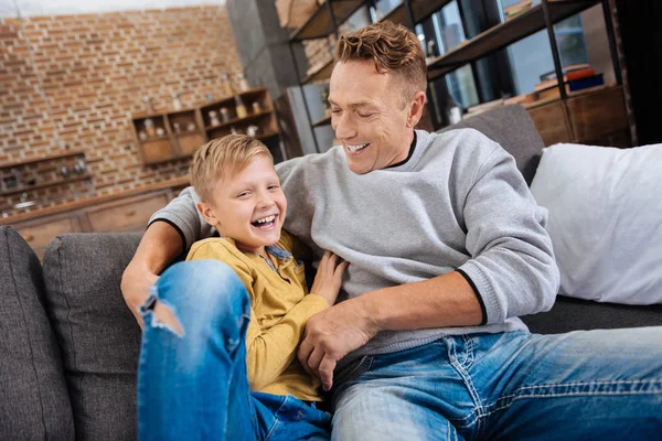 Feliz padre haciendo cosquillas a su hijo y riéndose con él —  Fotos de Stock