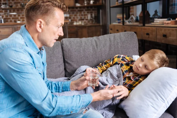 Gondoskodó apa ad gyógyszert a beteg fia — Stock Fotó