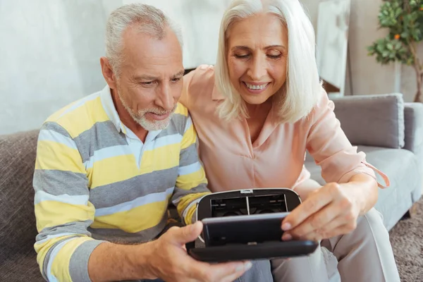 Alegre jubilado pareja poner inteligente teléfono dentro de de de VR gafas —  Fotos de Stock