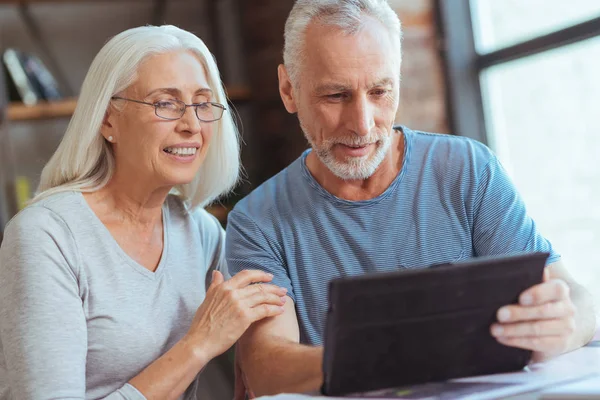 Rentnerehepaar nutzt Tablet zu Hause — Stockfoto