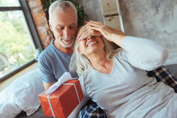Kärleksfull åldern man ger närvarande till sin fina fru — Stockfoto