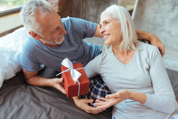 Веселая пожилая любящая пара с подарком — стоковое фото