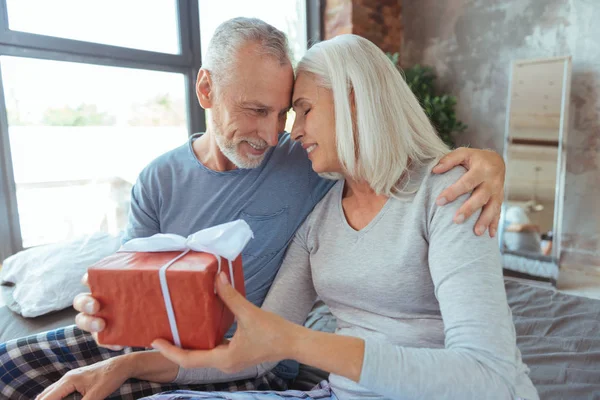 Delighetd kärleksfulla åldern par håller en födelsedagspresent — Stockfoto