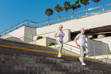 Merdivenlerden aşağı çalışan sportif yaşlı çift