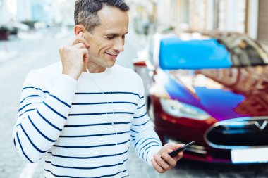Neşeli keyifli adam onun akıllı telefon ekranına bakarak