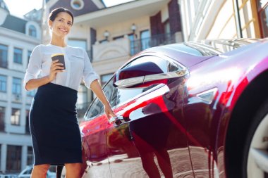 Bir fincan kahve ile holding neşeli mutlu işkadını